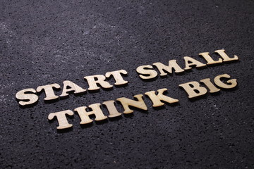 Fototapeta na wymiar Start small think big, business motivational inspirational quotes; wooden words typography lettering concept