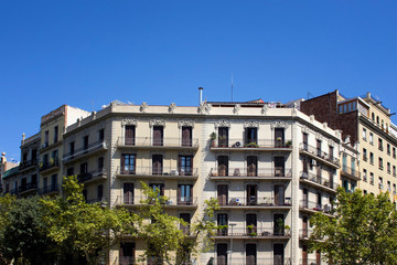 Fototapeta na wymiar View of traditional, historical, typical residential buildings in Barcelona showing Spanish / Catalan architectural style. It is a sunny summer day.