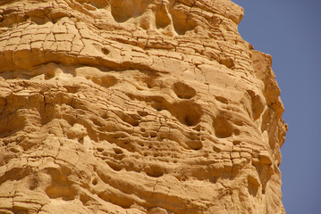 a wall of ancient Sandstone against a blue sky