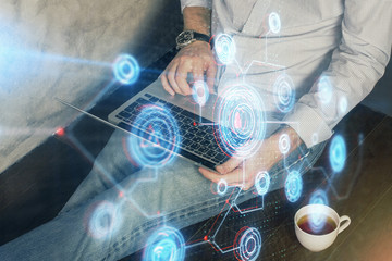 Multi exposure of data internet theme hologram with man working on computer on background. Concept of innovation.