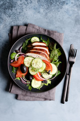 Roasted turkey or chicken breast with vegetables. Cucumbers, tomatoes, onions, olives and spices. Healthy salad for dinner