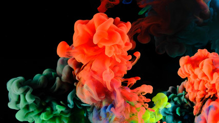 Fototapeta premium Color paint drops in water , abstract color mix , drop of Ink color mix paint falling on water Colorful ink in water, 