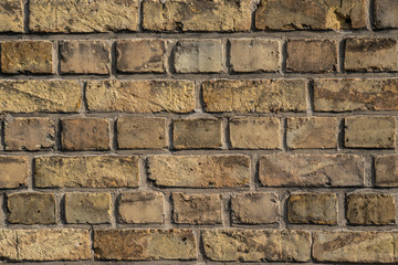 Texture of yellow and sand colored bricks in the sun