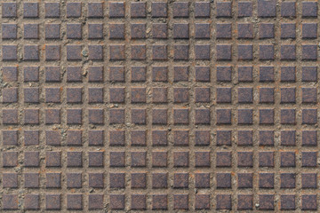 Texture of metal squares on a rusted metal plate
