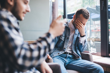 Adult male friends having conversation in cafe