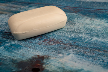 A piece of toilet soap on a wooden background. Close up. Regular thorough hand washing with soap is a prevention of COVID-19 infection.