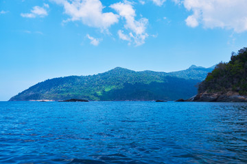 Landscape of the line of the rainforest, from the ocean. Tropical island in Indian Ocean. Uninhabited and wild subtropical isle with palm trees. Blank sand on a tropical island.