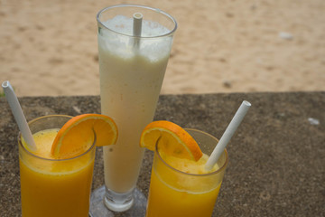orange juice in transparent glasses and a milkshake