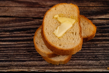 Fresh wheat toast with butter on a wooden background. Close up.
