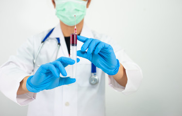 The doctor holds the syringe and the patient's blood sample for examination.