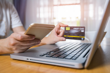 Woman using smart mobile phone with credit card for online shopping.