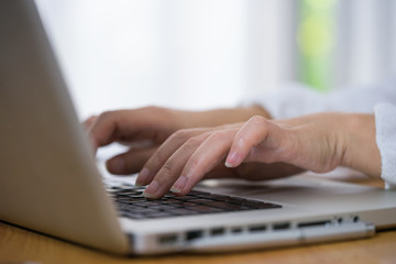 Cropped shot of a woman using a laptop while working from home