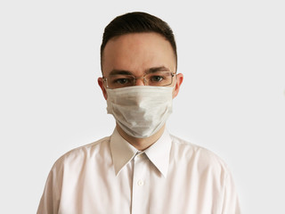 Portrait of a man in a disposable mask and glasses on a white background. Medical worker in a mask and glasses. Isolation 2020. 2020 virus protection.