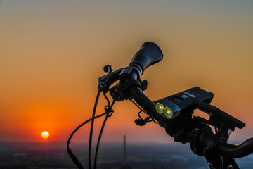 Handlebar mirror and light on electric bike in sunset color evening