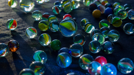 Marbles scattered with rays of light hitting the background.