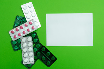many handkerchiefs with pills and a white envelope on a green background. place for text