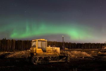 The bulldozer in the background of the Northern lights