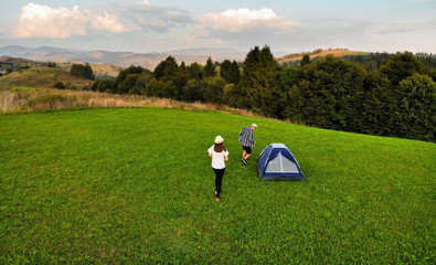 Aerial view of love couple of hikers spend time together away from city bustle by sunrise in...