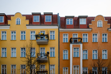 Front view of two facades of yellow and orange colors of typical houses in the German district of Friedrichshain