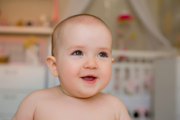 Portrait of a cute baby girl smiling looks into the camera