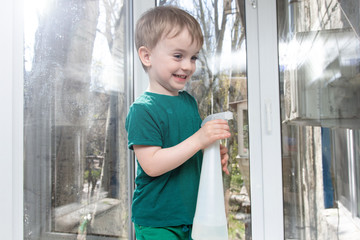 little boy washes a window. help mom. quarantined leisure