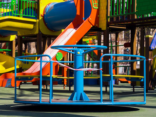 Little carousel with restriction tape on empty playground during coronavirus