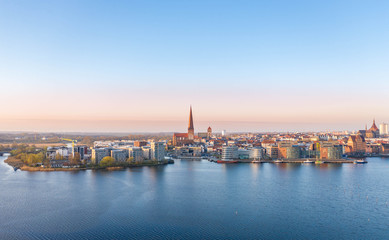 Naklejka na ściany i meble panorama of the city of rostock - aerial view over the river warnow, skyline during sunrise
