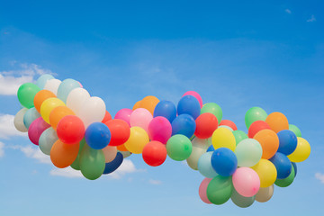 Balloons of many colors Floating in the air and the backdrop is a beautiful sky and clouds