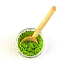 dry green tea powder matcha tea with a wooden spoon, isolate on a white background