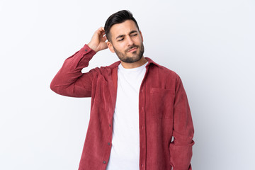 Young handsome man with beard wearing a corduroy jacket over isolated white background having doubts while scratching head