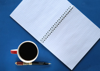 coffee in a cup, pen, and sheets with free space for inscription
