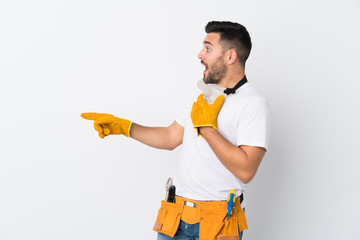 Craftsmen or electrician man over isolated white background pointing finger to the side