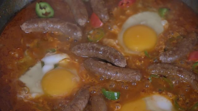 Close up shot of wiener sausages and egg on the grill slow motion