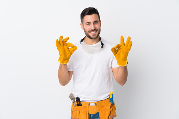 Craftsmen or electrician man over isolated white background showing an ok sign with fingers