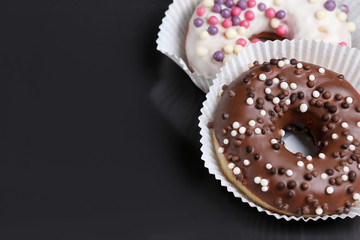 chocolate and white chocolate donuts  on a black plate and wooden table. Morning espresso. Morning cappuccino 
