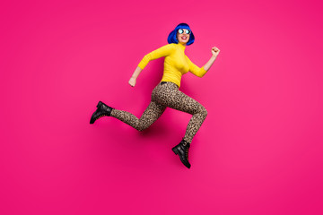 Full body photo of cool lady traveler jump high rush discount shopping center wear specs yellow turtleneck blue short wig boots leopard trousers isolated bright pink color background © deagreez