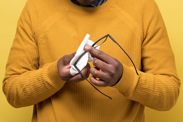 Young african american man cleaning glasses with a piece of tissue