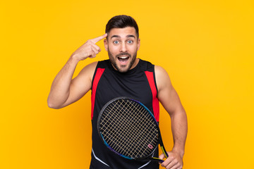 Tennis player man over isolated yellow wall intending to realizes the solution