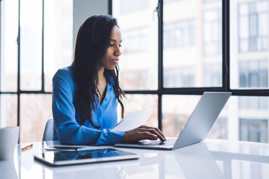 Black Woman Bringing Data To Laptop From Paper Sheet