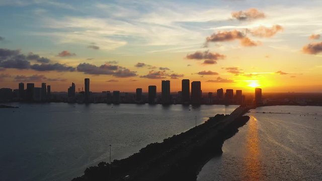Aerial rotate down of golden sunset of Miami Beach and Biscayne Bay and the Julia Tuttle Causeway