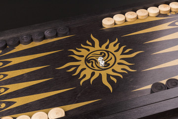 Backgammon. Board game. White cubes and chips on a blackboard.  Dice on backgammon board game. Selective focus. Playing leisure games