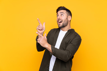 Man over isolated yellow background pointing with the index finger a great idea