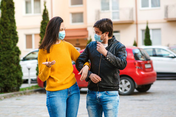 Woman and man wearing face mask at street. Coronavirus epidemic. Young couple outdoors. Protect pollution, anti smog and viruses. Air pollution caused health problem.