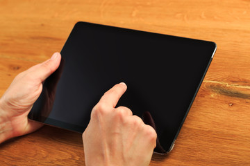 female hands holding tablet on wooden background  , place for your text  .