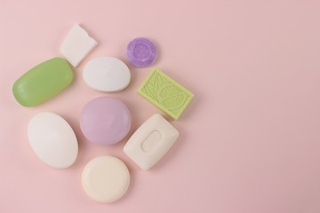 Hygiene and prevention of viral illness concept. Various soap bar on a pink background with copy space. Top view