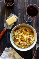Pasta spaghetti carbonara on a wooden background. Italian cuisine. Recipe. Rustic style. Wine.
