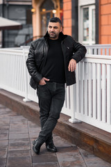 a man in a leather jacket on the background of the metropolis. eastern appearance of the model.