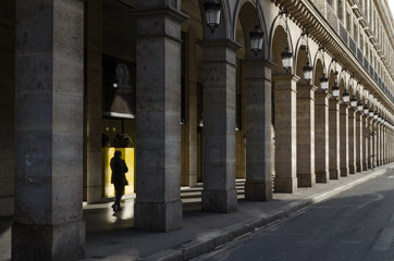 Architectural structure made up of a series of columns while a person walks between them