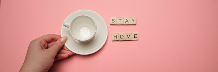stayhome with woman hand holding coffee cup on bright pink background