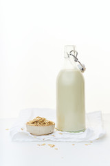Oat milk in a glass bottle. Dairy alternative. Healthy vegan protein drink